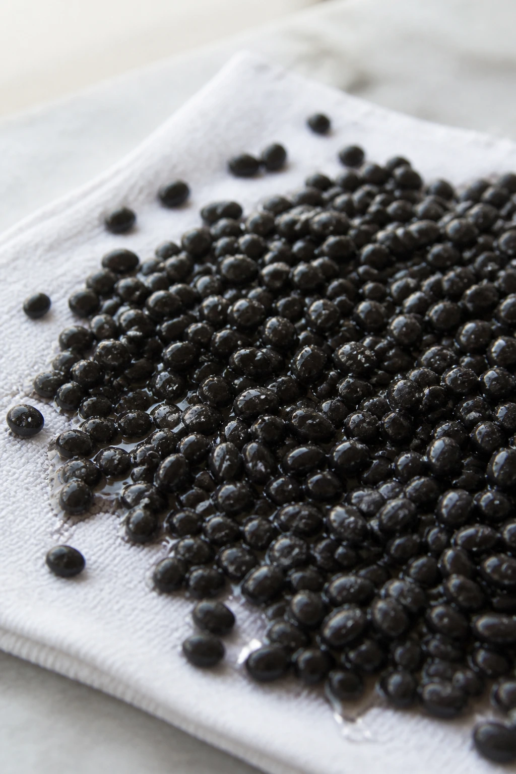 Macro shot of wet black beans on a towel, illustrating common mistakes to avoid.