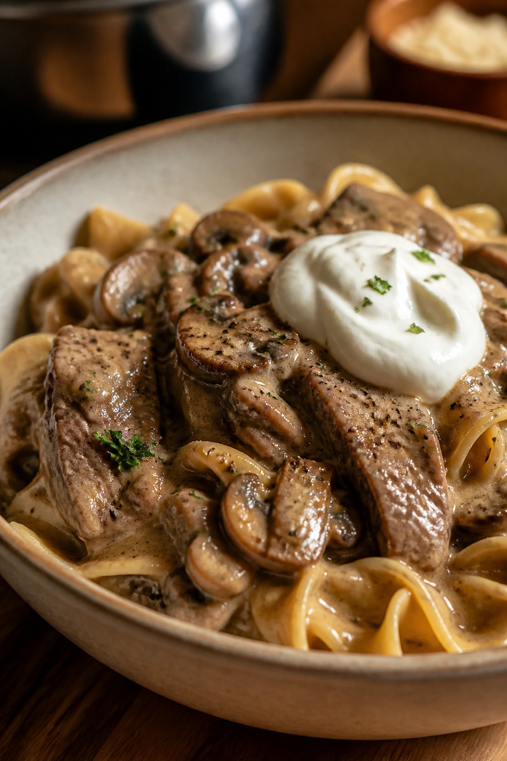 Close-up of beef stroganoff with mushrooms and sour cream in a rustic bowl
