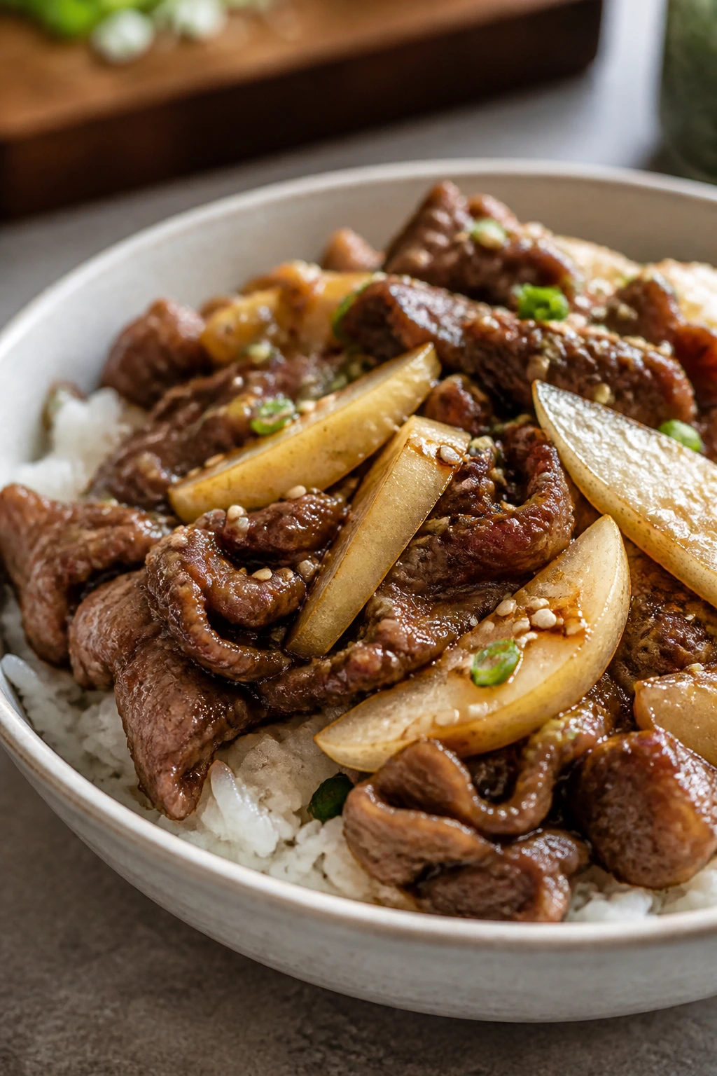 Close-up of bulgogi sirloin rice bowl with pear and sesame over rice