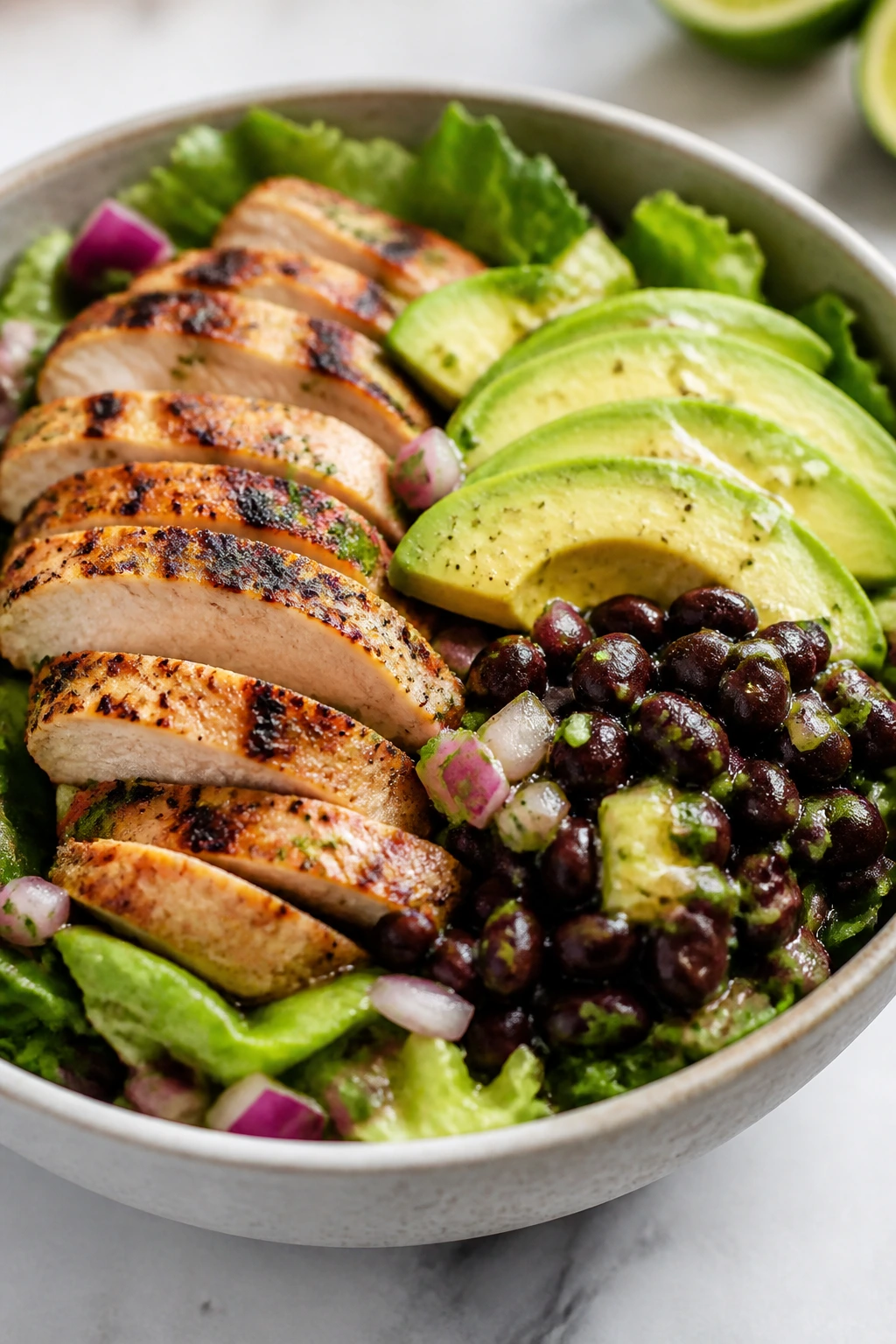 Vibrant chicken avocado and black bean dinner salad in a bowl on a kitchen counter