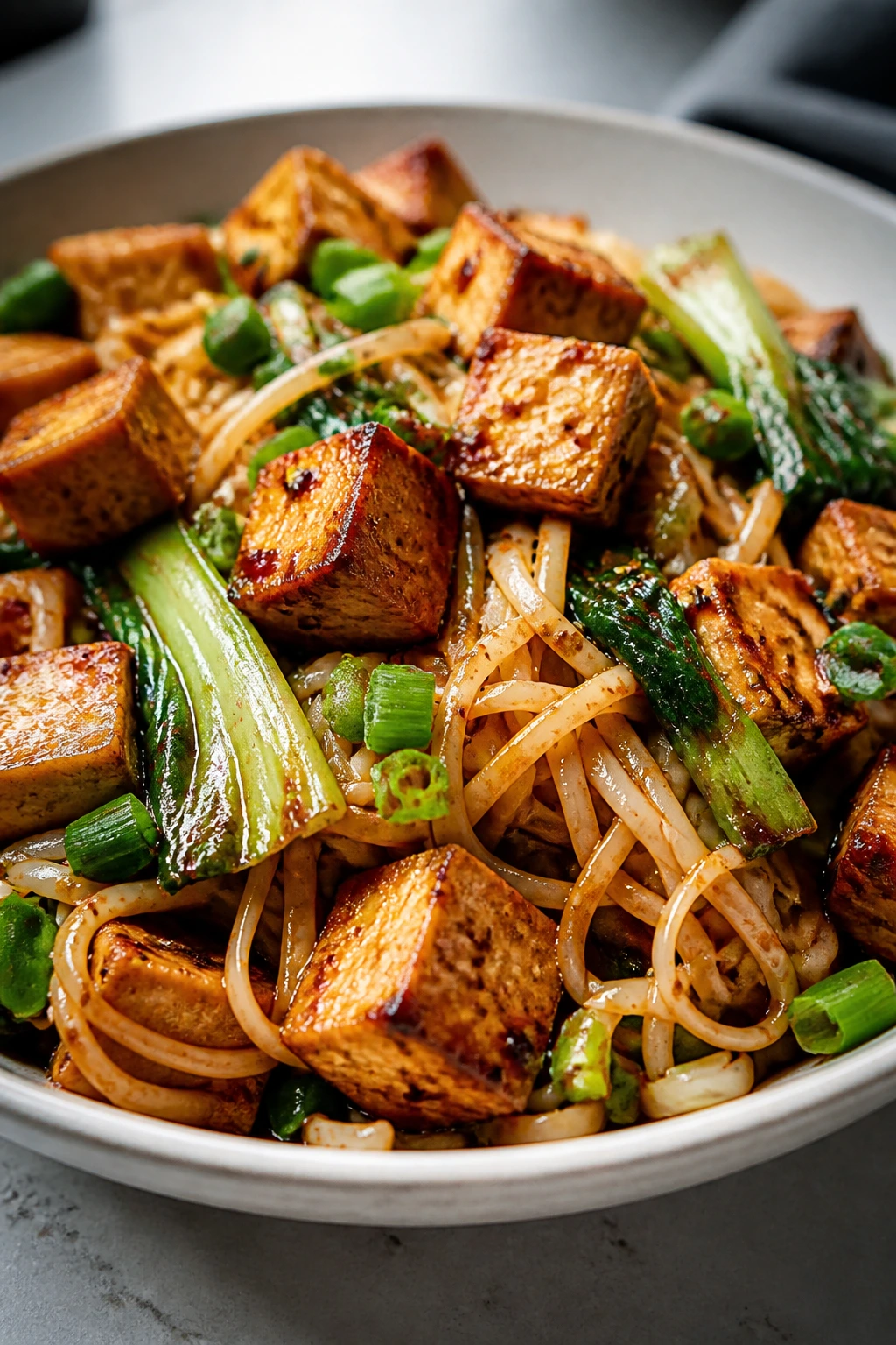 Tofu with chili garlic sauce on noodles and greens