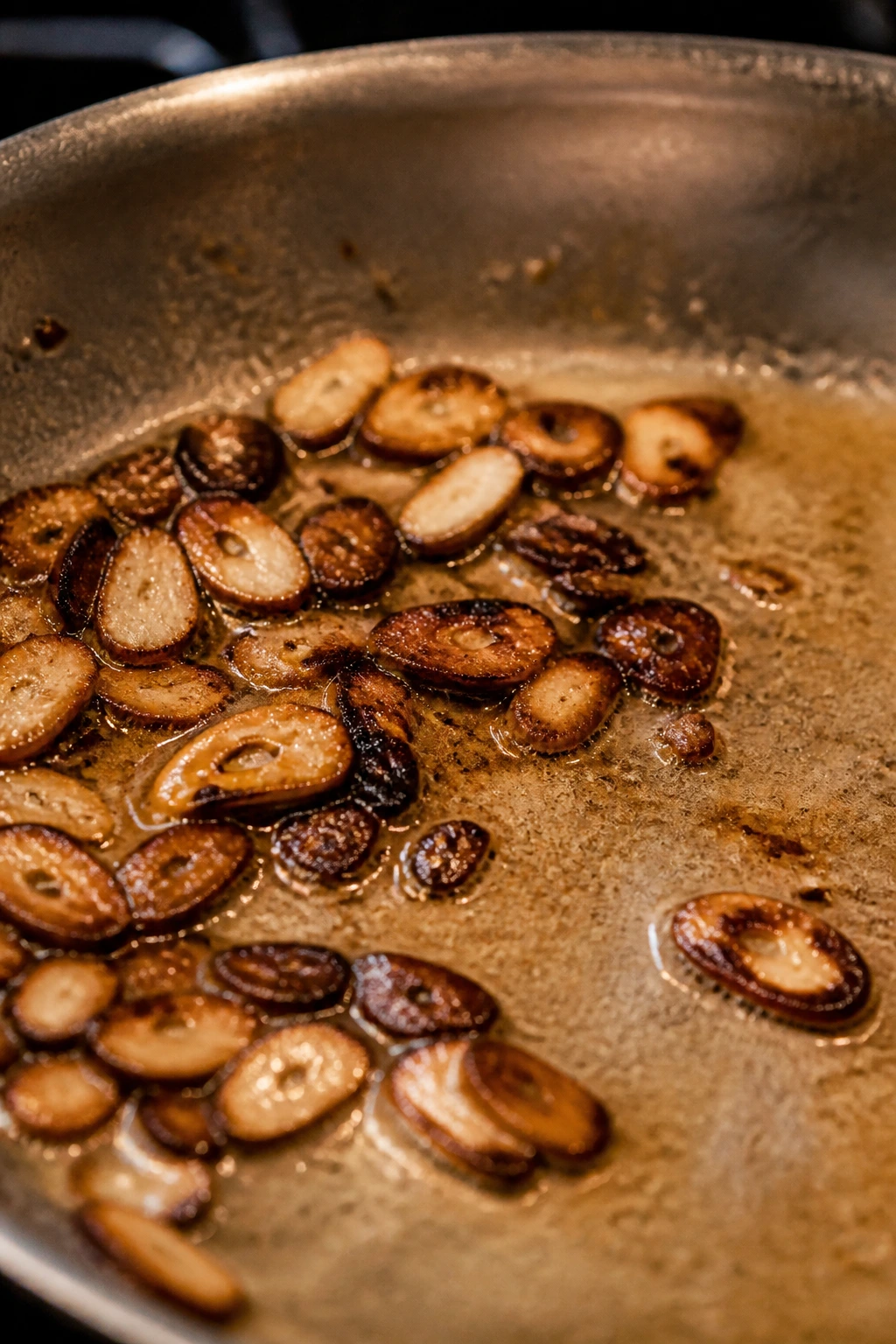Burnt garlic in a pan illustrating a common pantry mistake