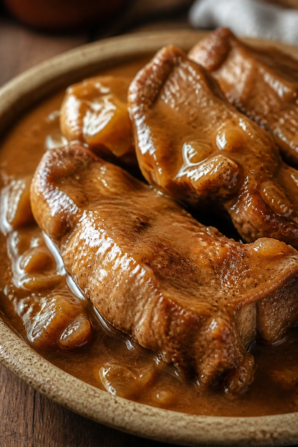 Glazed country-style ribs with pan gravy on a rustic plate