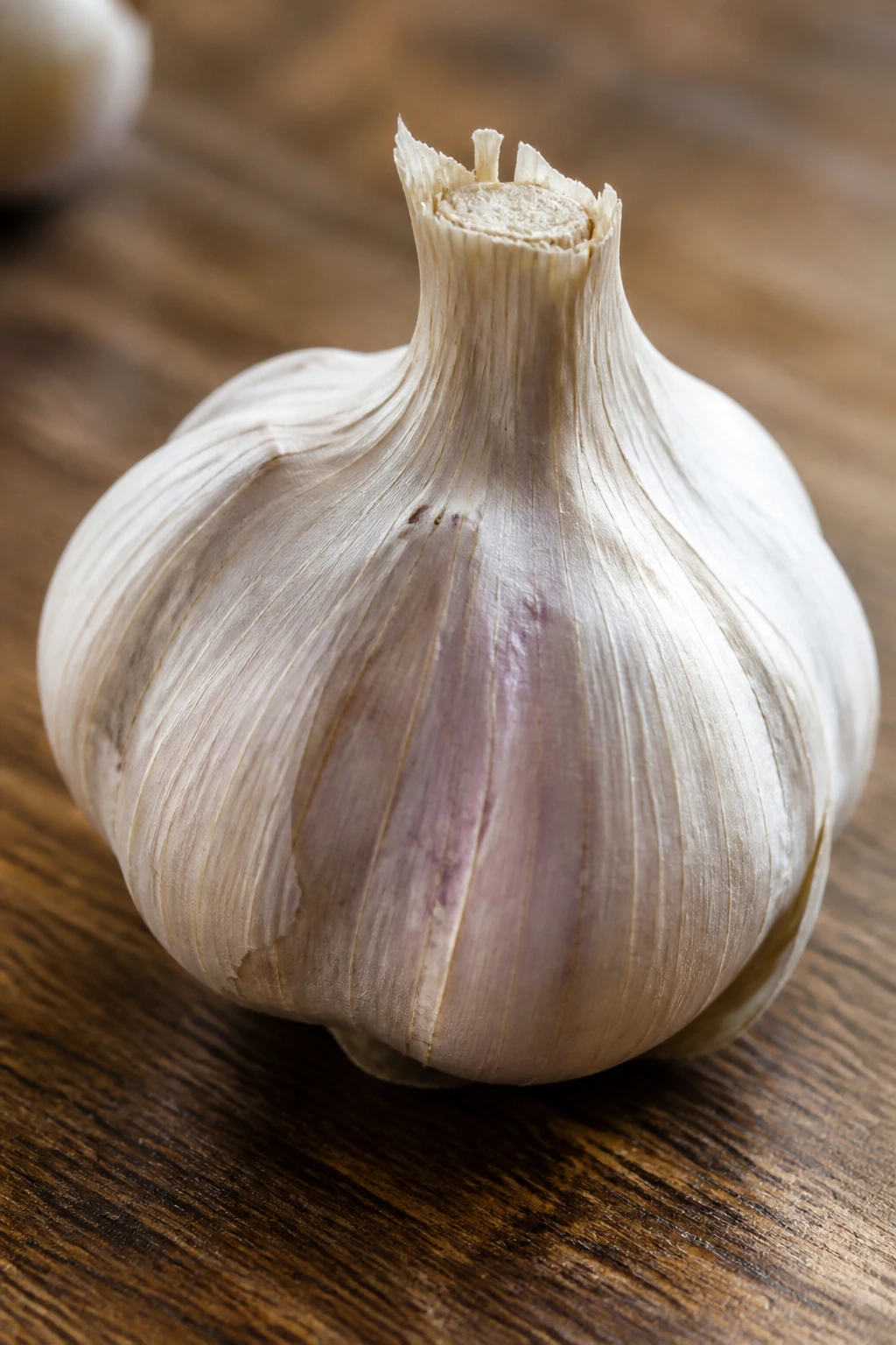 Single garlic bulb on a wooden countertop