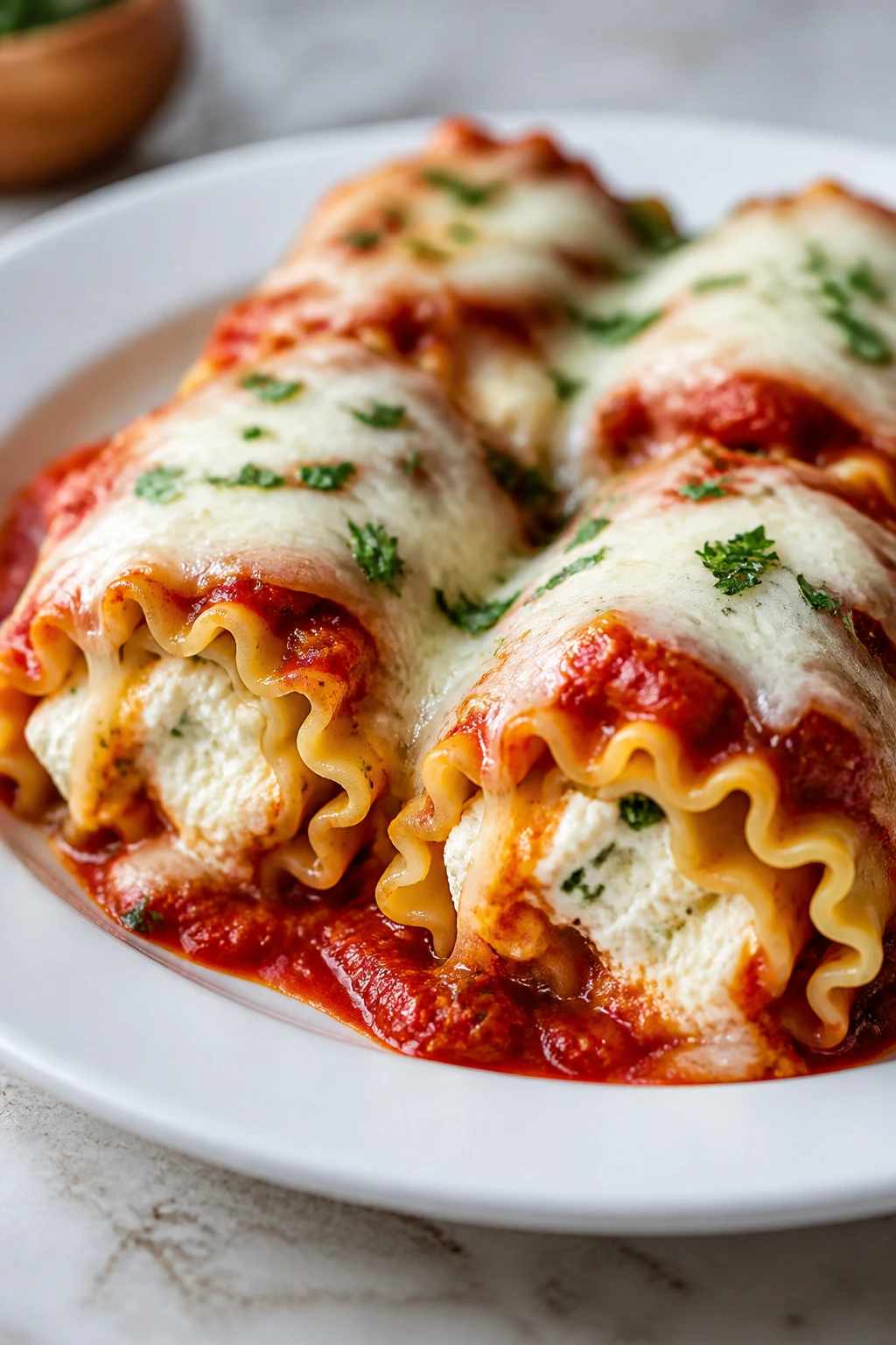 Lasagna roll-ups on a plate with ricotta filling