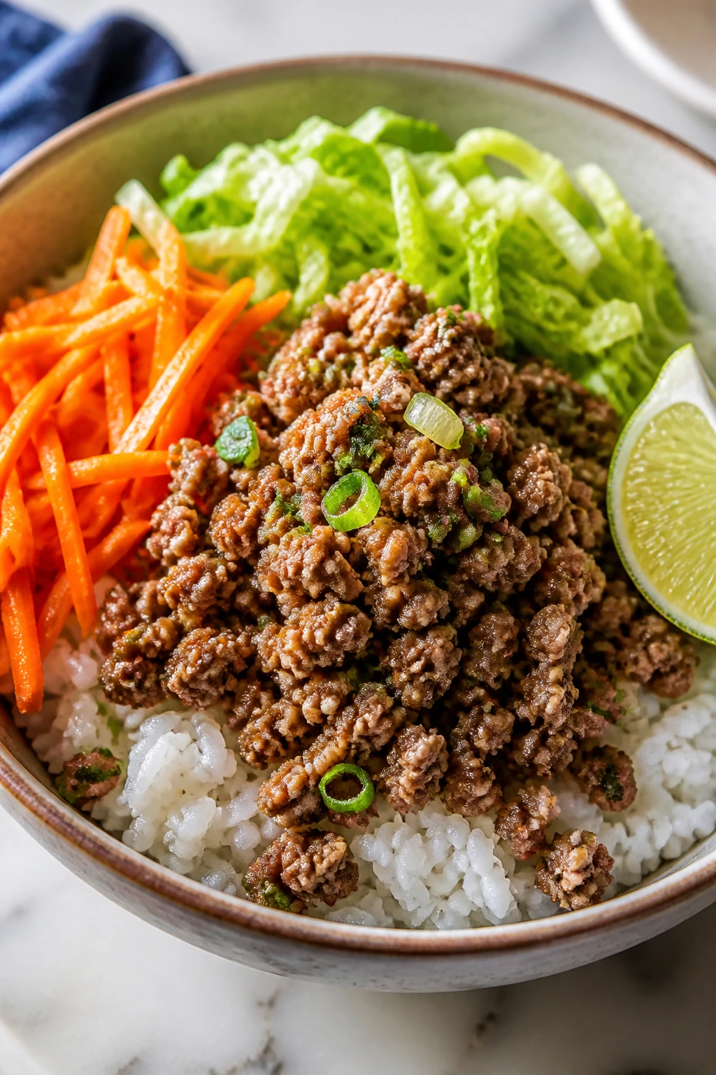 Close-up of lemongrass pork rice bowl with lettuce and carrot