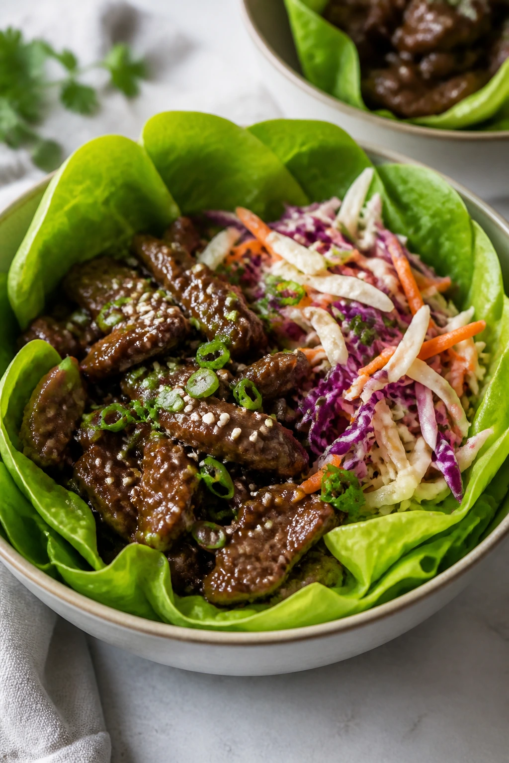 Close-up bowl with lettuce wraps, beef, and crunchy slaw