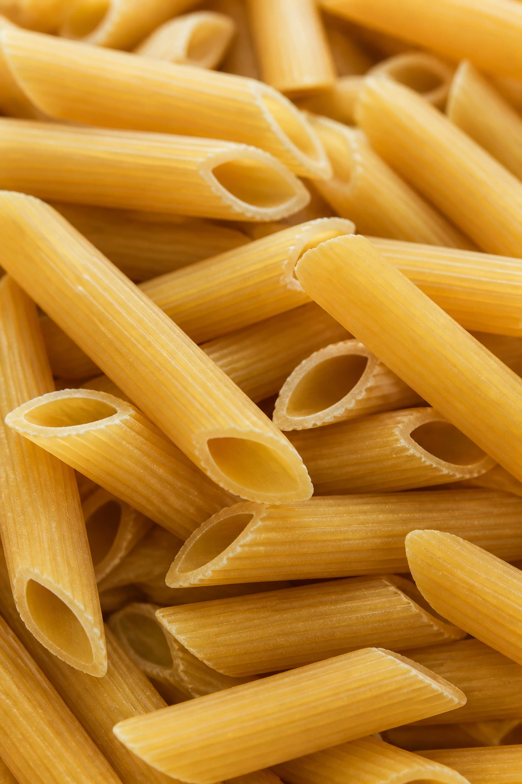 Close-up of a penne pasta shape filling the frame.