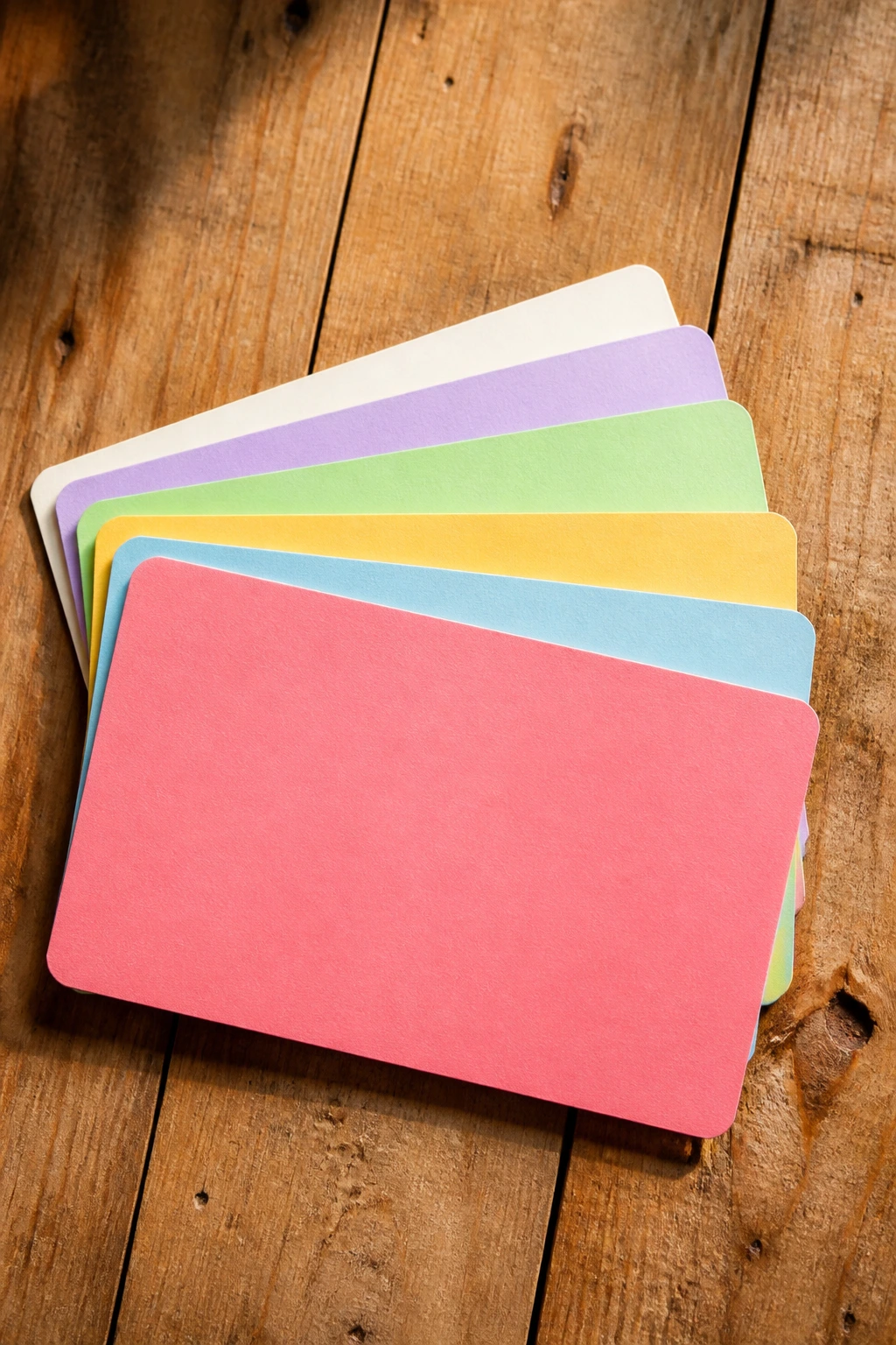 Top-down view of blank recipe cards arranged on a wooden table.