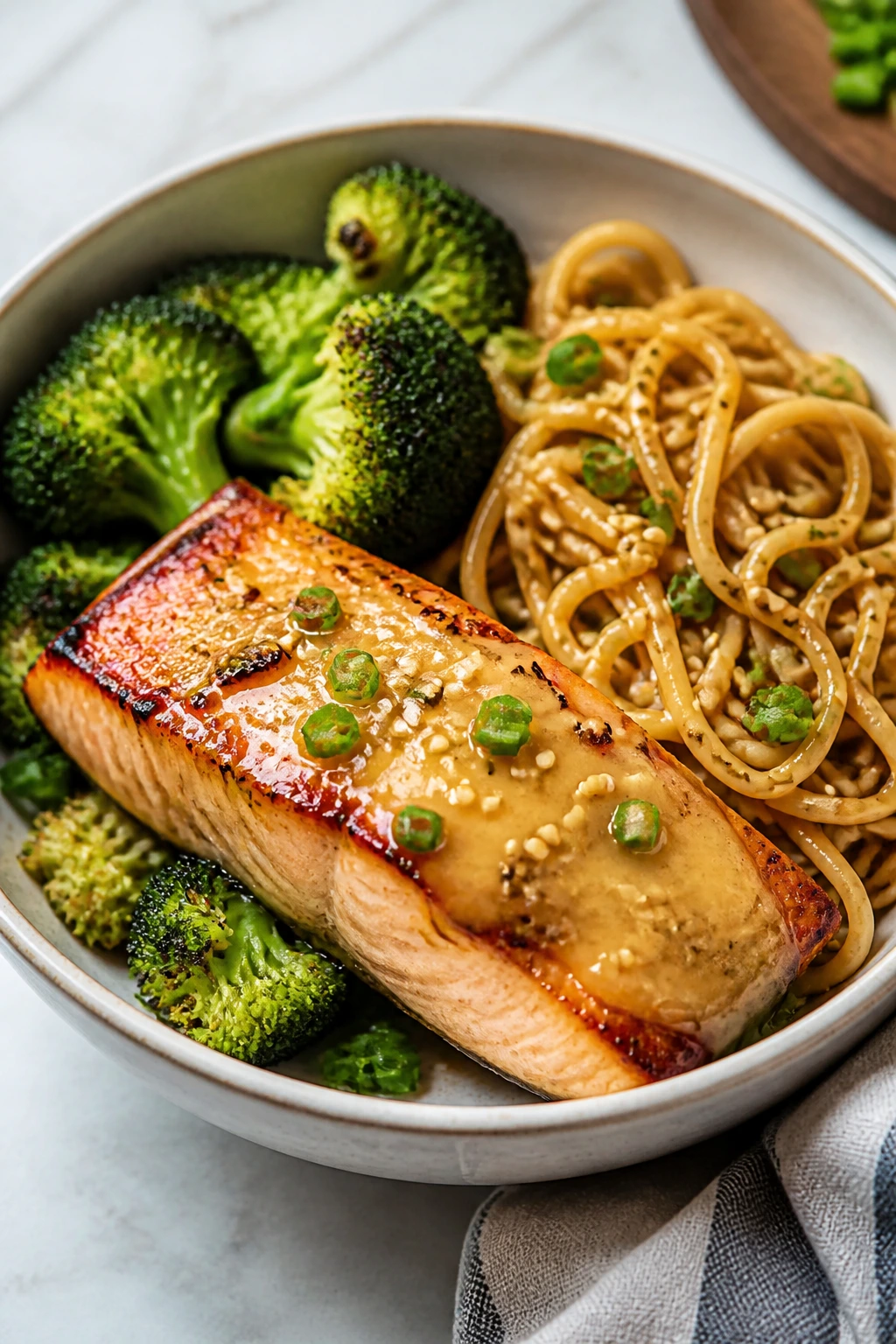 Close-up miso glazed salmon with broccoli and sesame noodles