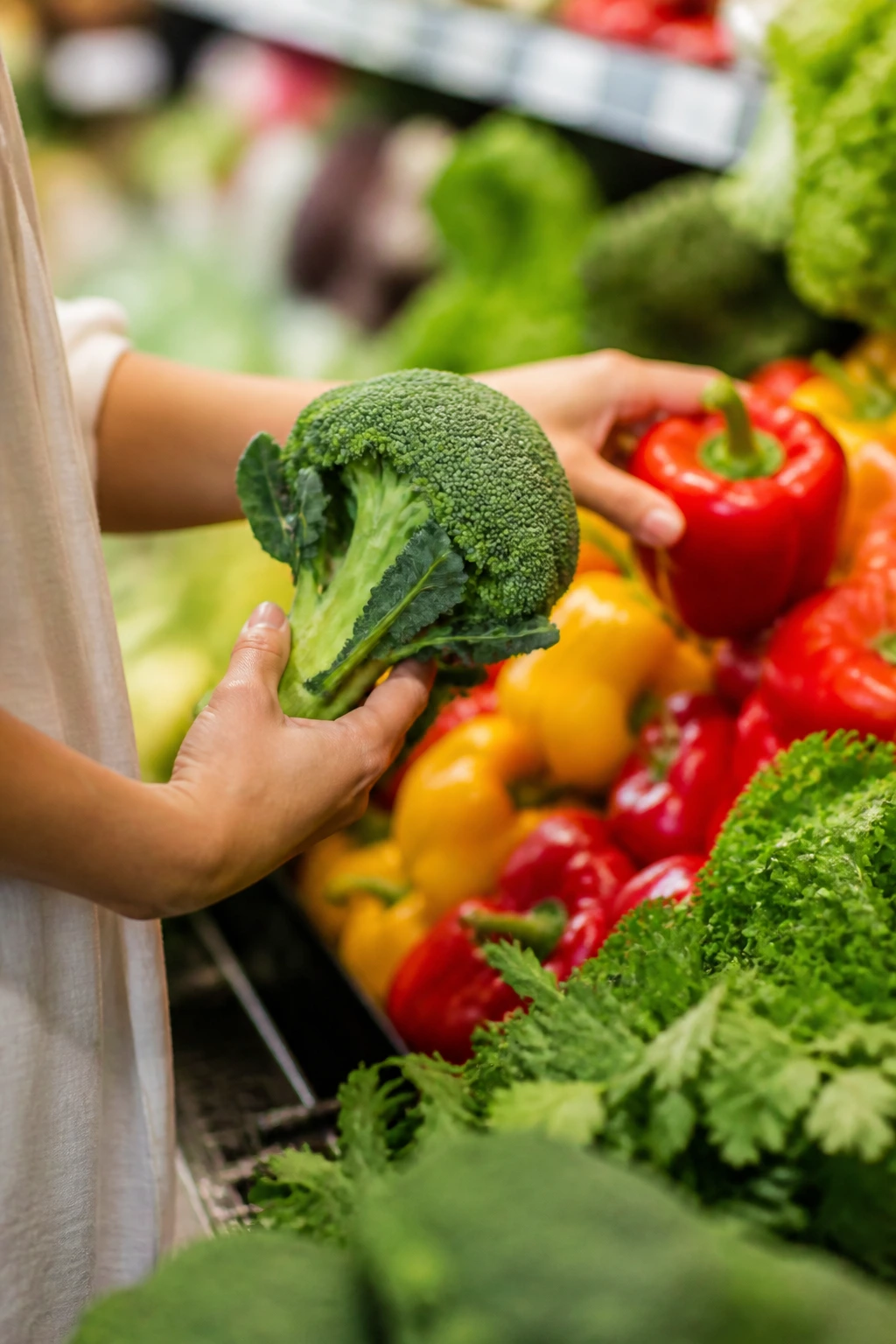 Hands selecting fresh produce in grocery store
