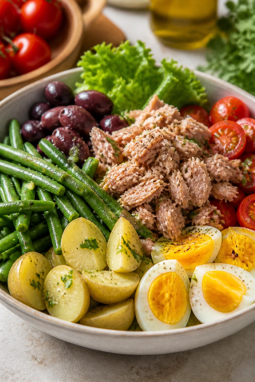 Close-up of a Niçoise salad with tuna, potatoes, beans, eggs, and olives