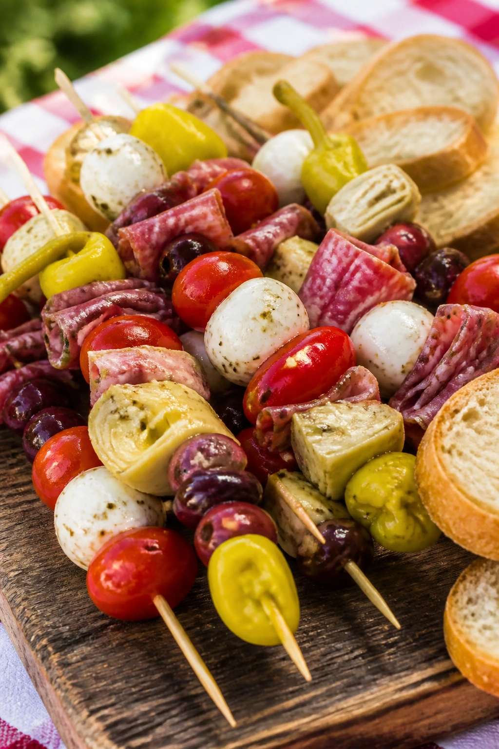Close-up Antipasto Skewers with bread on a picnic board.