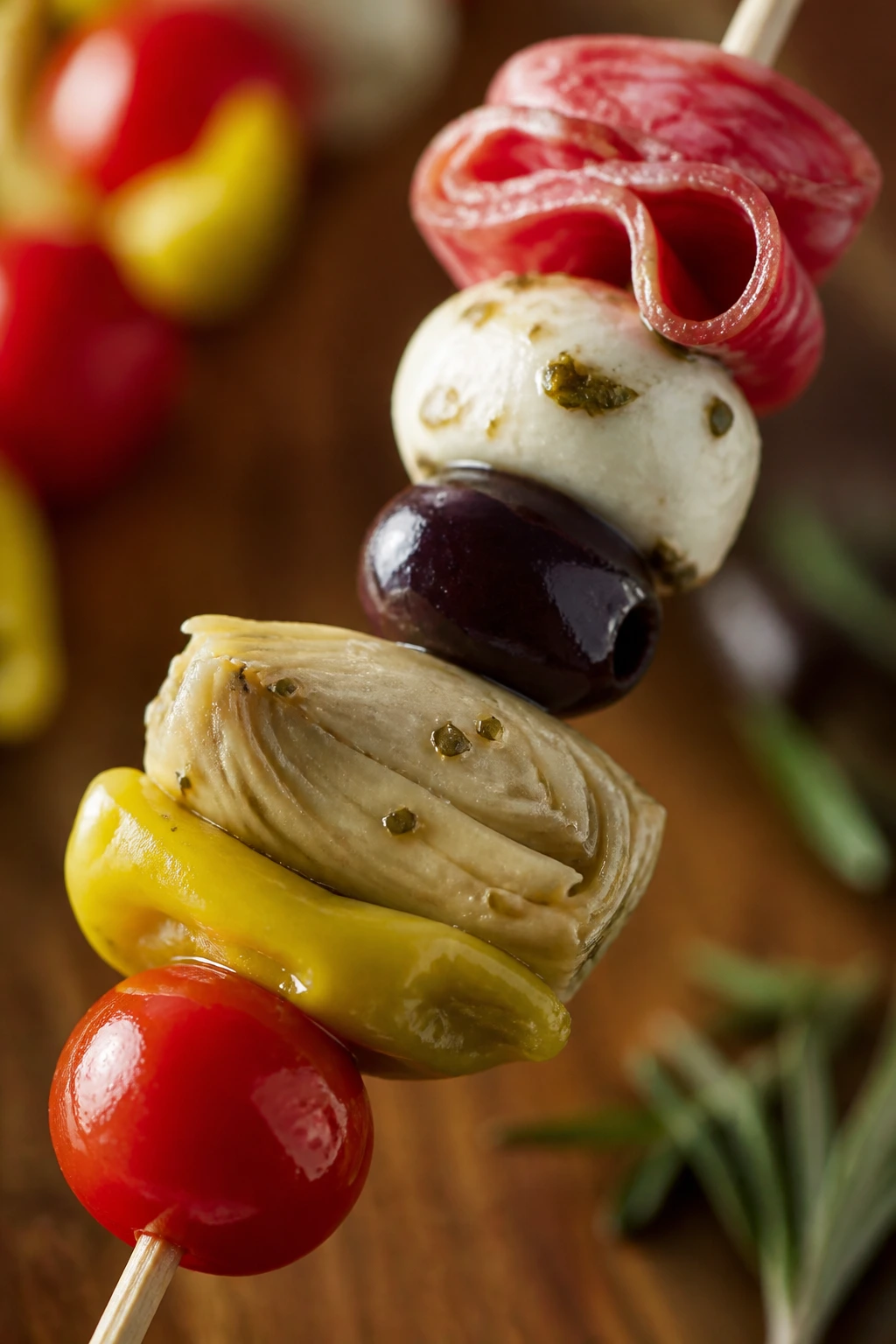 Antipasto skewer with meats, cheese and olives on wood board