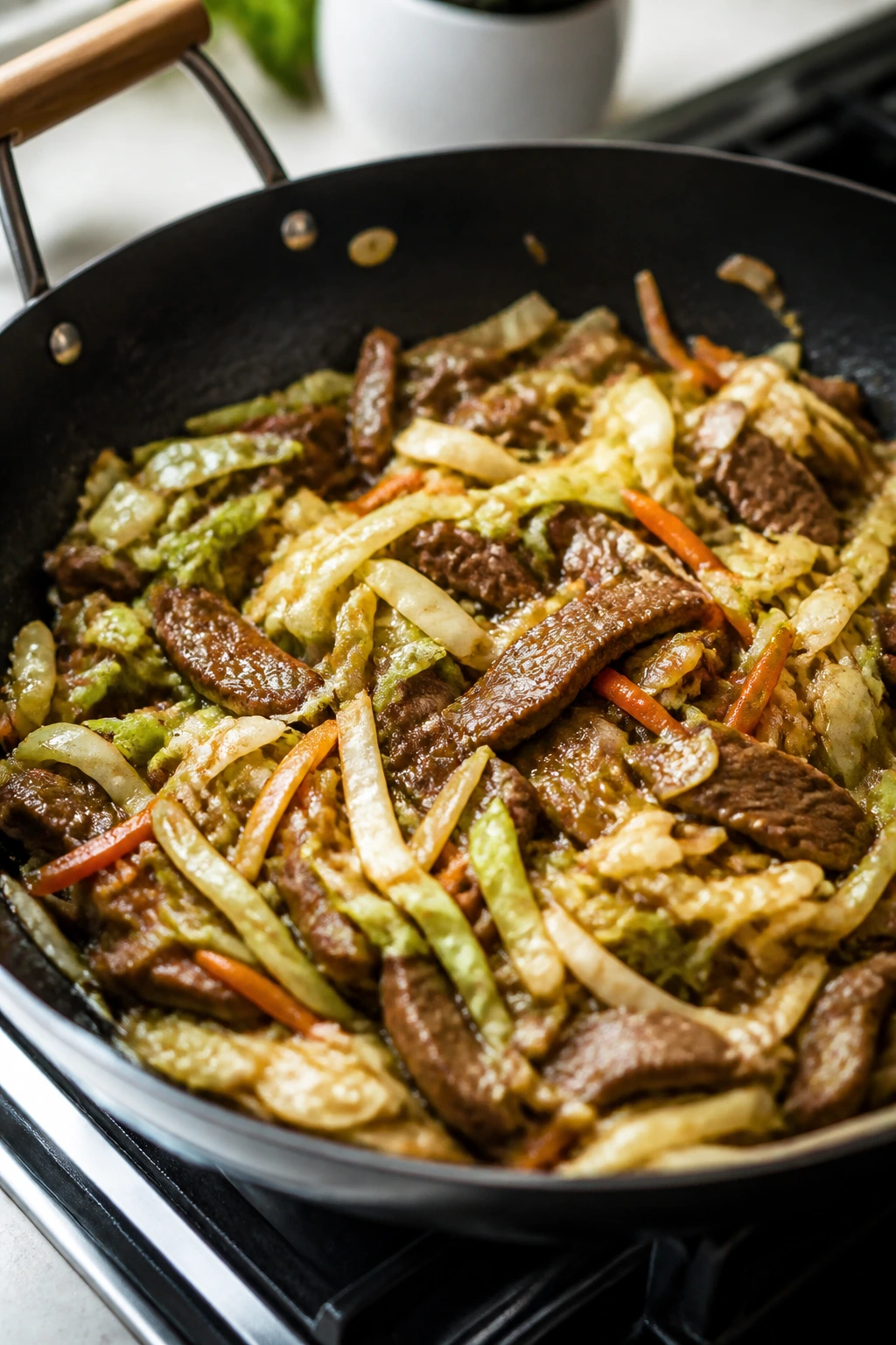 Beef and cabbage stir-fry in a skillet with cabbage and carrots