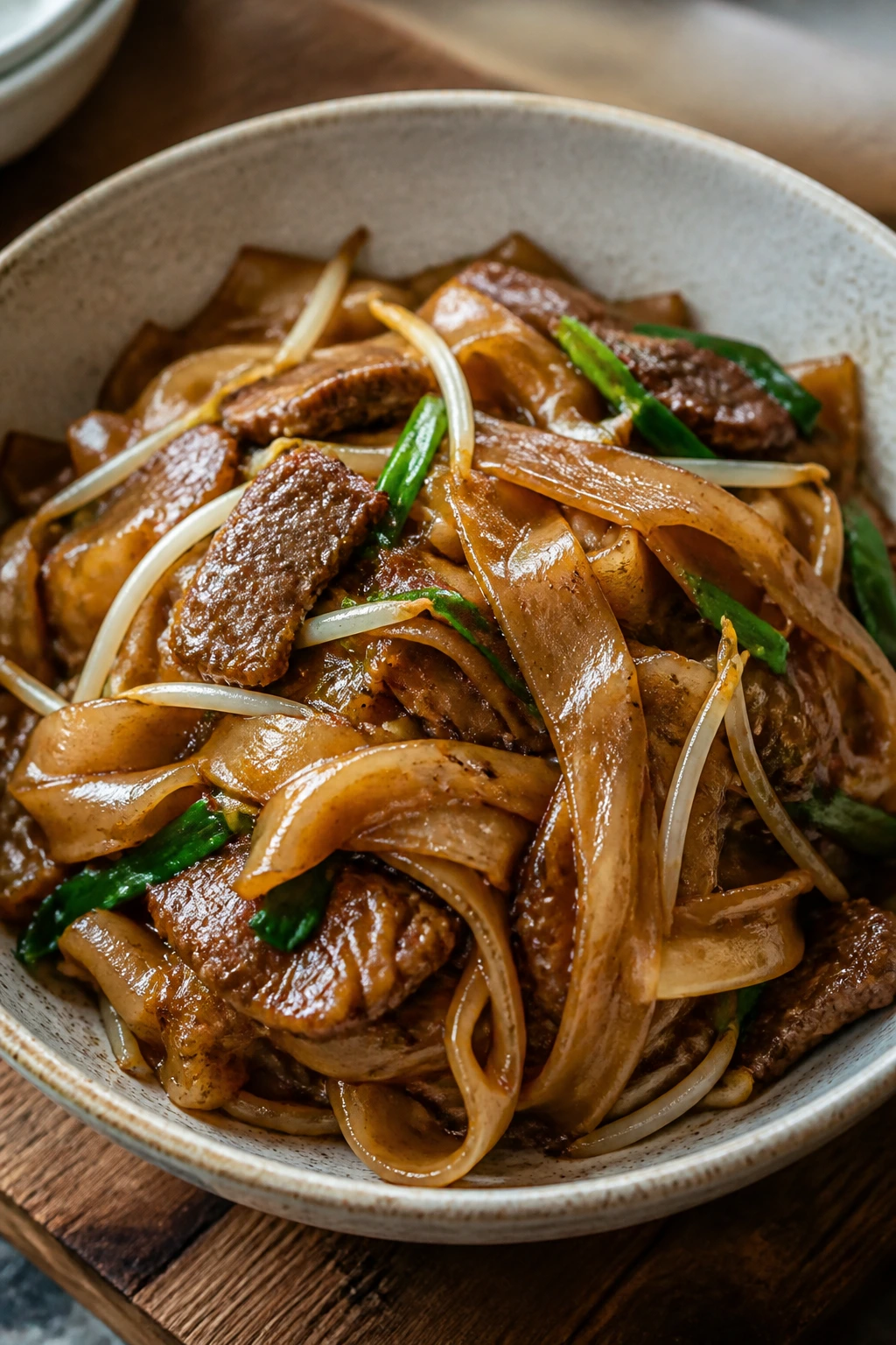 Beef chow fun with wide noodles, beef, and bean sprouts