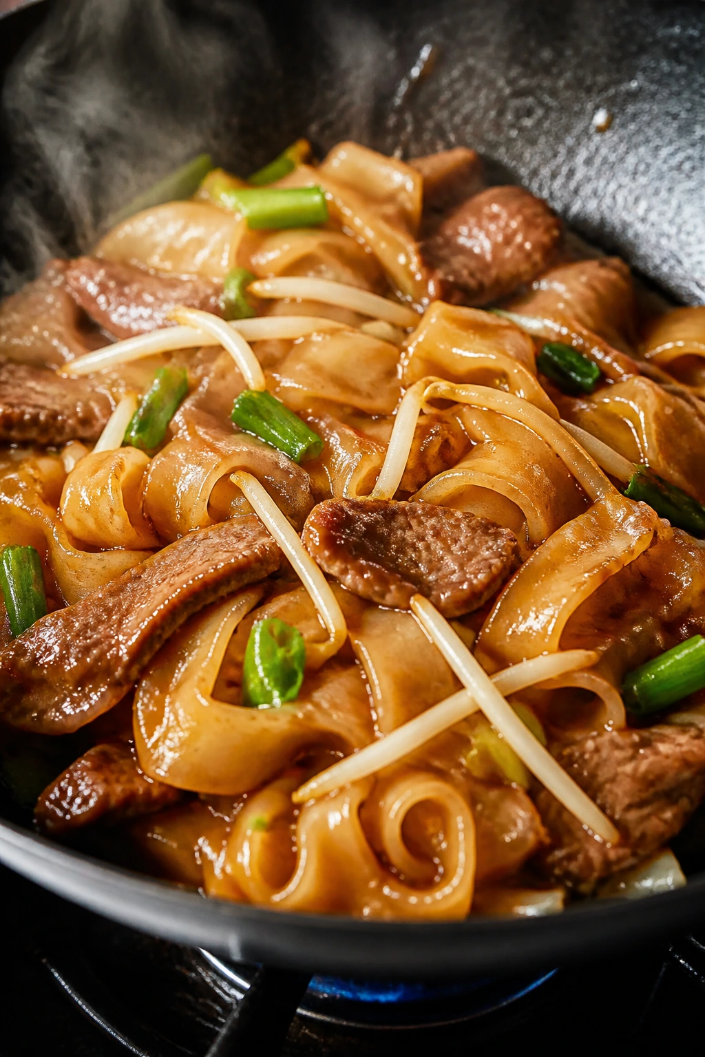 Close-up of Beef Ho Fun noodles and beef in glossy sauce