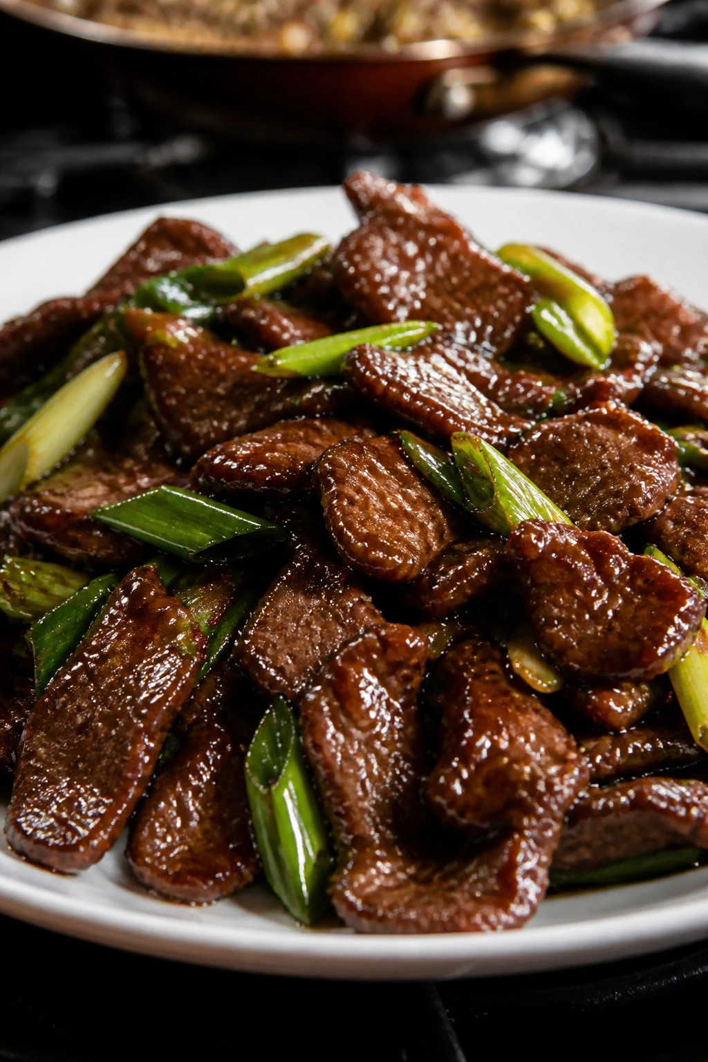 Close-up of Mongolian beef with glossy sauce and scallions