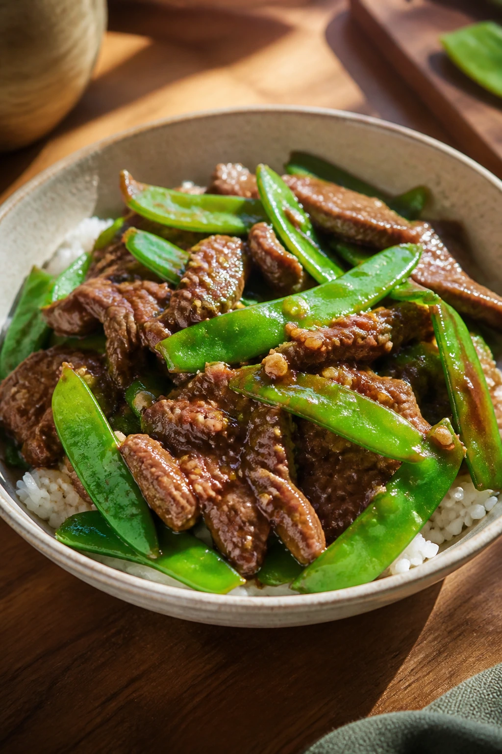 Beef slices with snow peas in sauce in a bowl