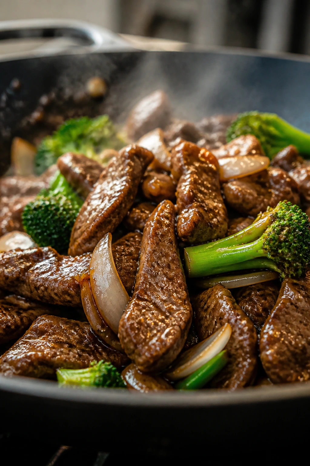 Beef slices browning in a pan with vegetables and glaze