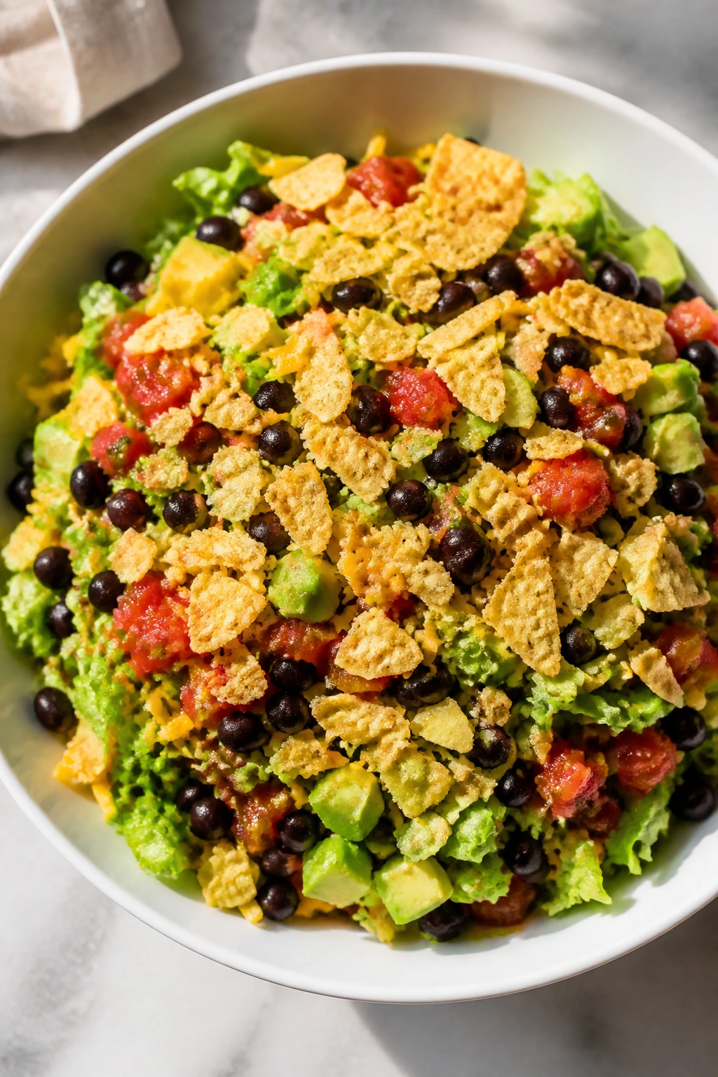 Bowl of black bean salsa taco salad with lettuce cheese and tortilla chips