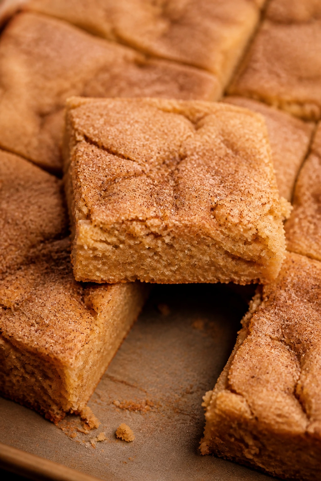 Close-up of cinnamon-sugar topped snickerdoodle blondies on a baking sheet