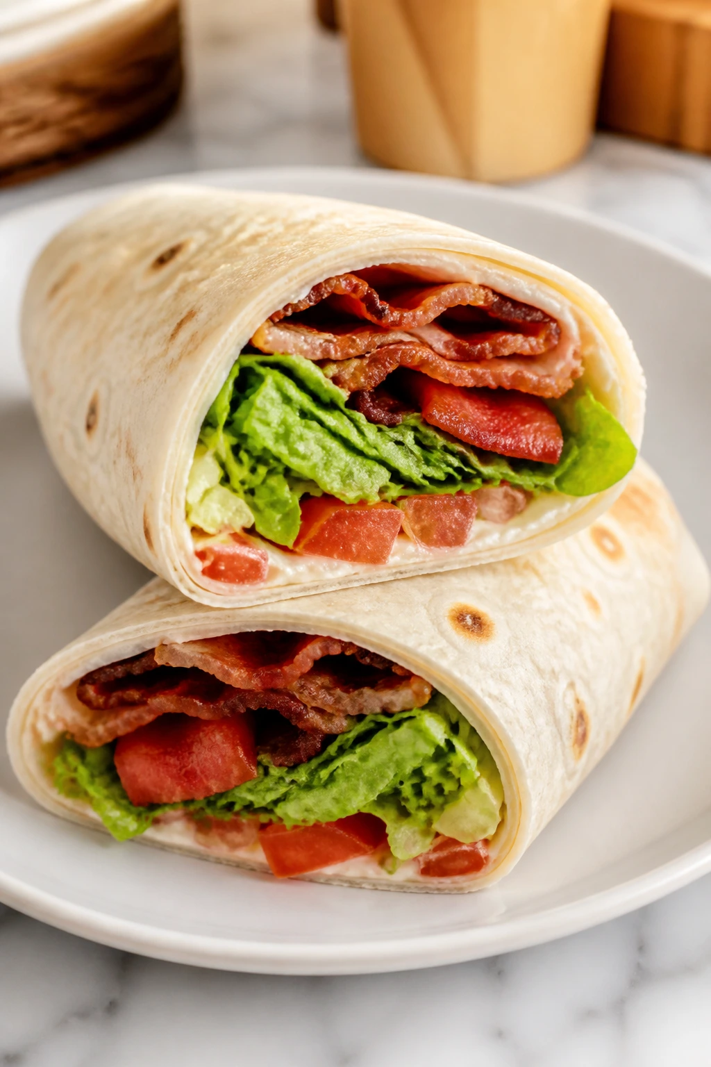 Close-up of BLT tortilla wrap halves with bacon, lettuce, and tomato
