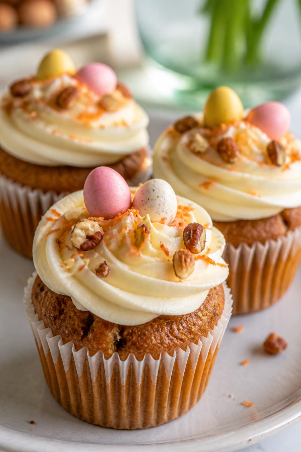 Close-up of carrot cake cupcakes with cream cheese frosting on a bright kitchen counter