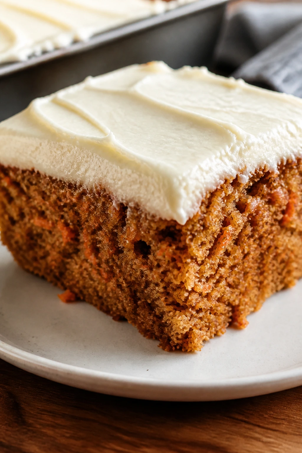 Close-up of carrot sheet cake slice with cream cheese frosting