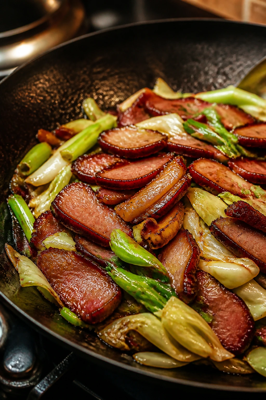 Close-up lacquered Char Siu pork with cabbage and scallions in a wok