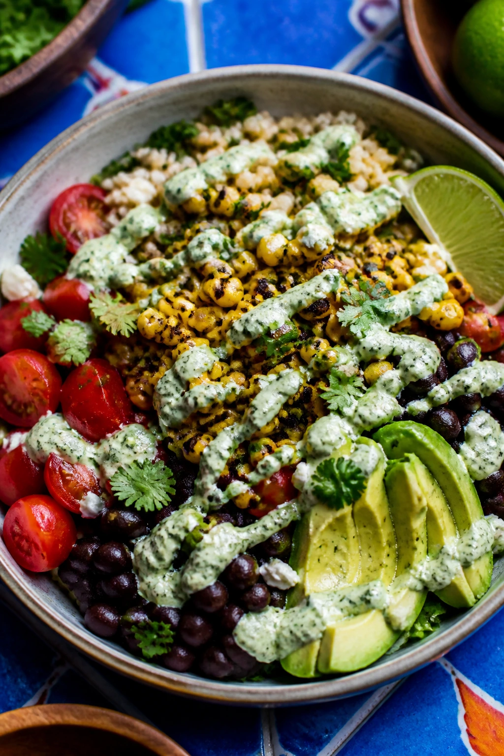 Close-up of a colorful corn and bean lunch bowl with avocado and lime crema