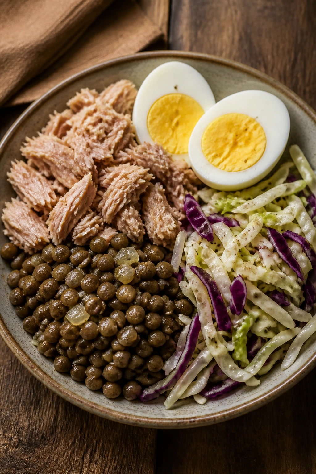 Close-up of a simple, repeatable lean plate with eggs, tuna, lentils and cabbage.