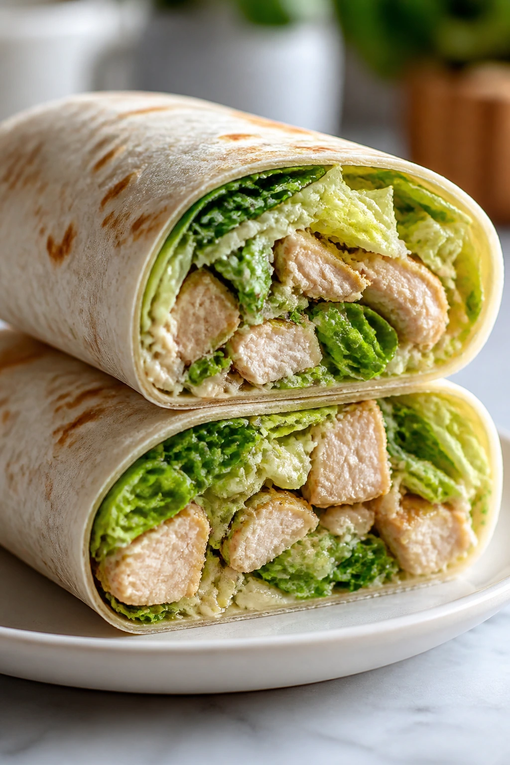 Chicken Caesar wrap cut in half on plate
