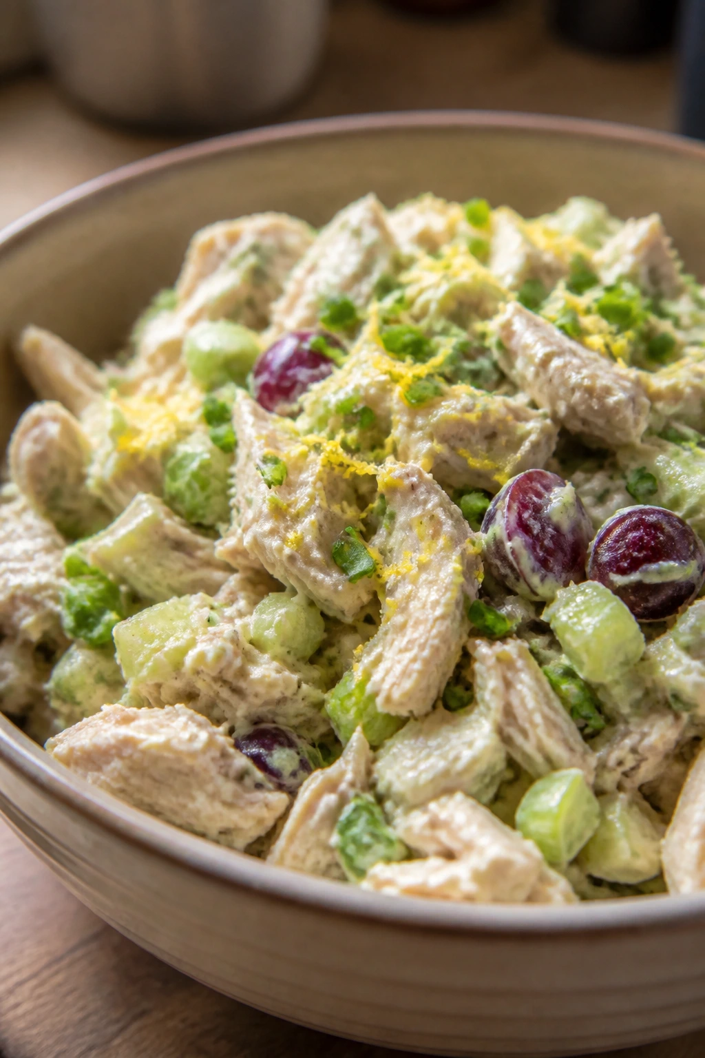 Chicken salad in a bowl with visible lemon zest and chives