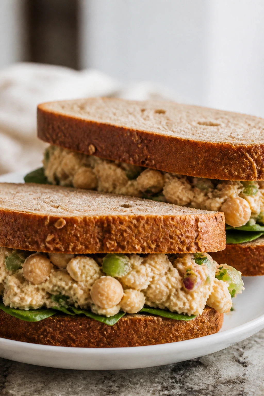 Chickpea salad sandwiches on a plate in a bright kitchen