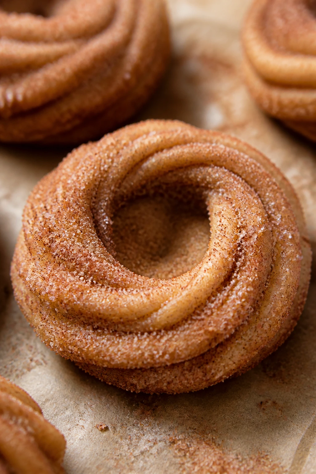 Close-up of a churro cinnamon nest cookie with cinnamon sugar on parchment