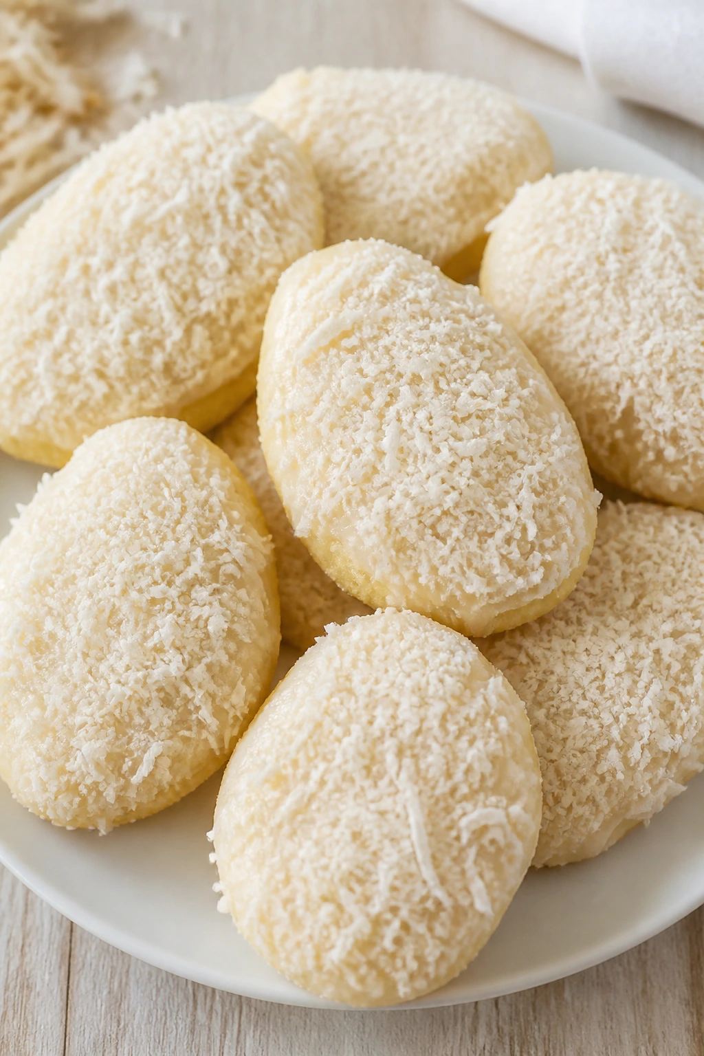 Close-up of coconut-topped Easter egg cookies on a plate
