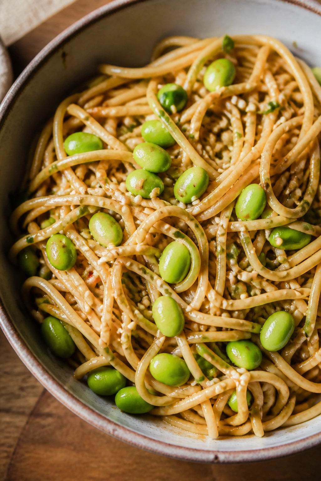 Bowl of cold sesame noodles with edamame and sesame seeds