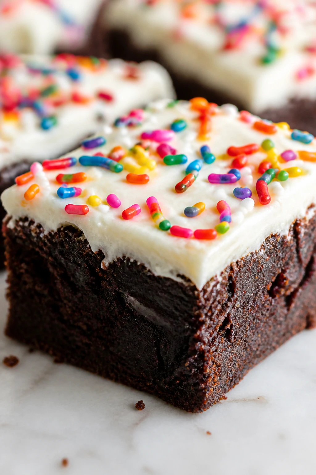 Brownie square with cream cheese frosting and rainbow sprinkles