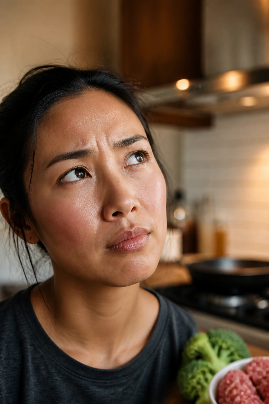Close-up of a thoughtful home cook in a kitchen, contemplating cooking questions before making a dish