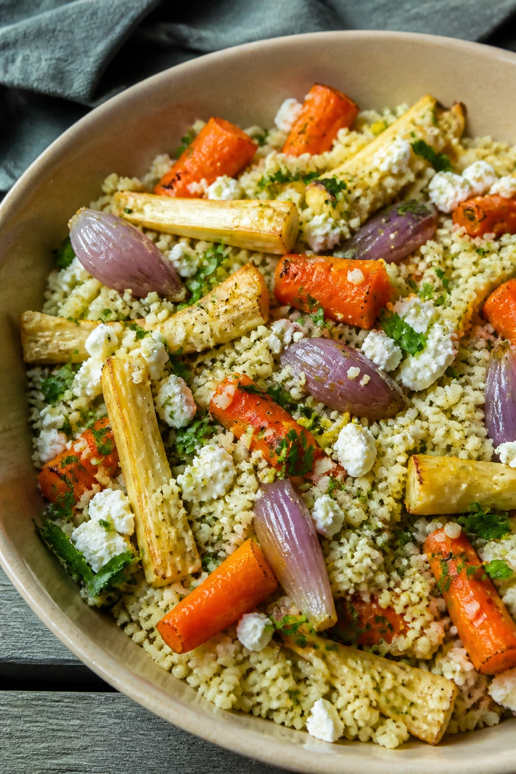 Winter vegetable couscous salad with roasted roots in a bowl on a picnic table.