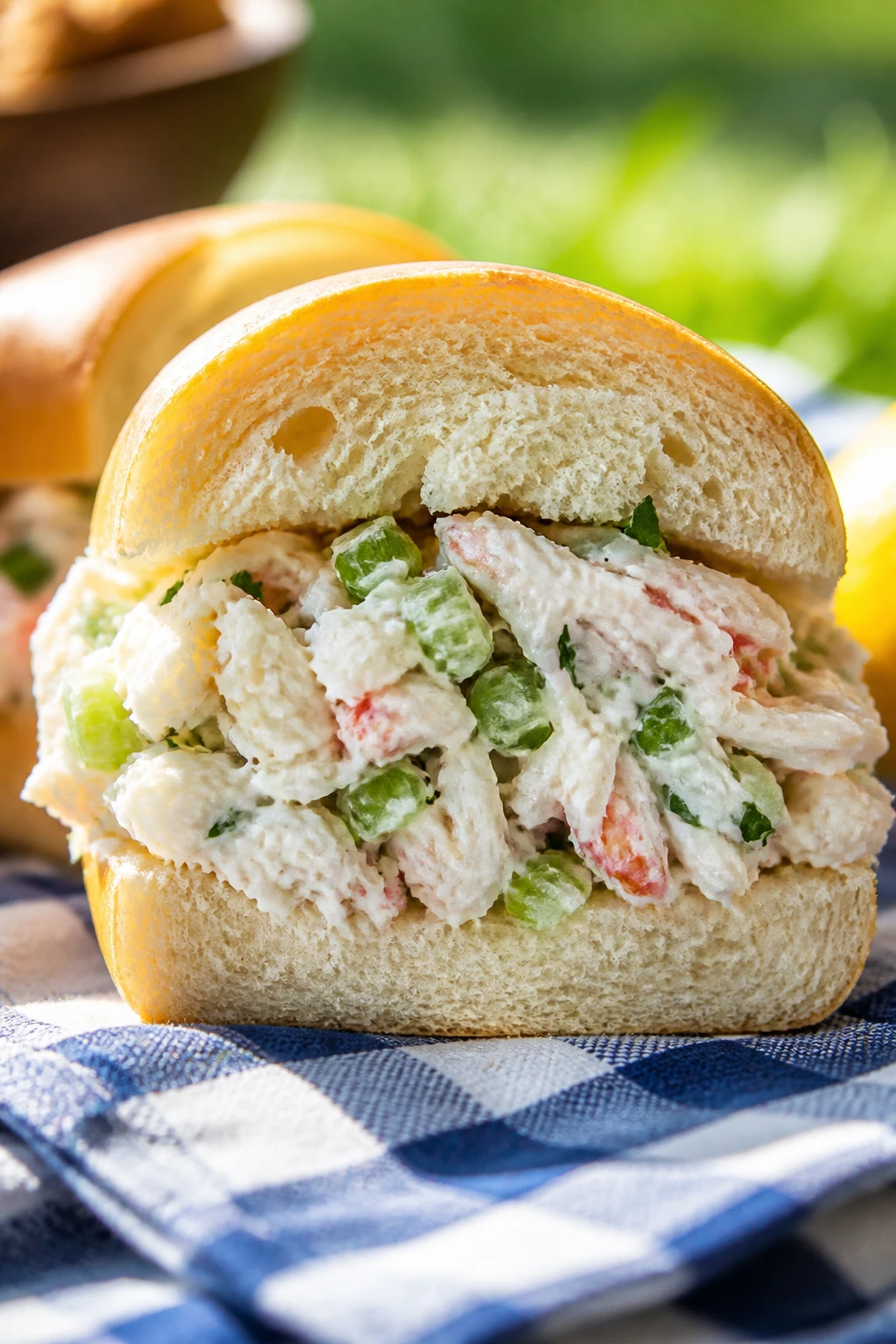 Cross-section crab salad sandwich on a soft roll at a sunny picnic
