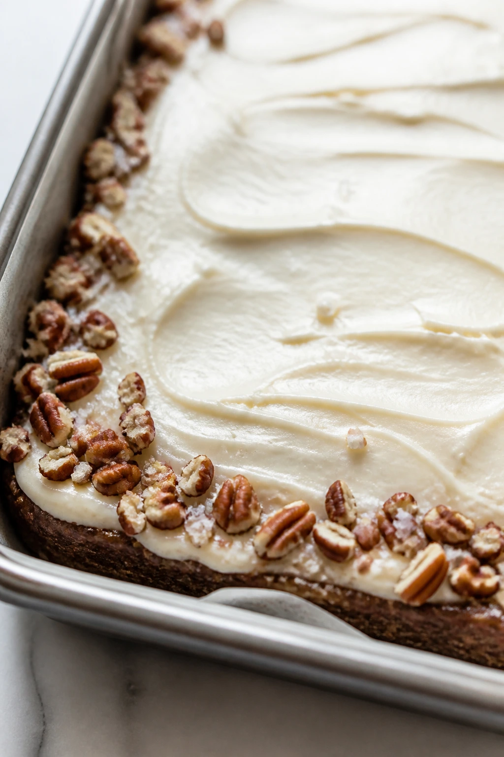 Close-up of silky cream cheese frosting spread on cooled bars