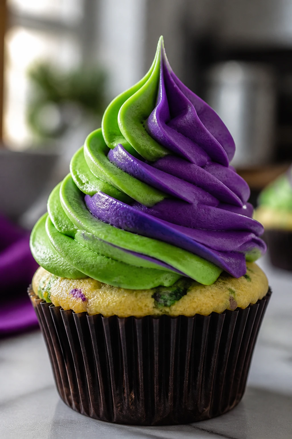 Cupcake with tall green and purple frosting swirl