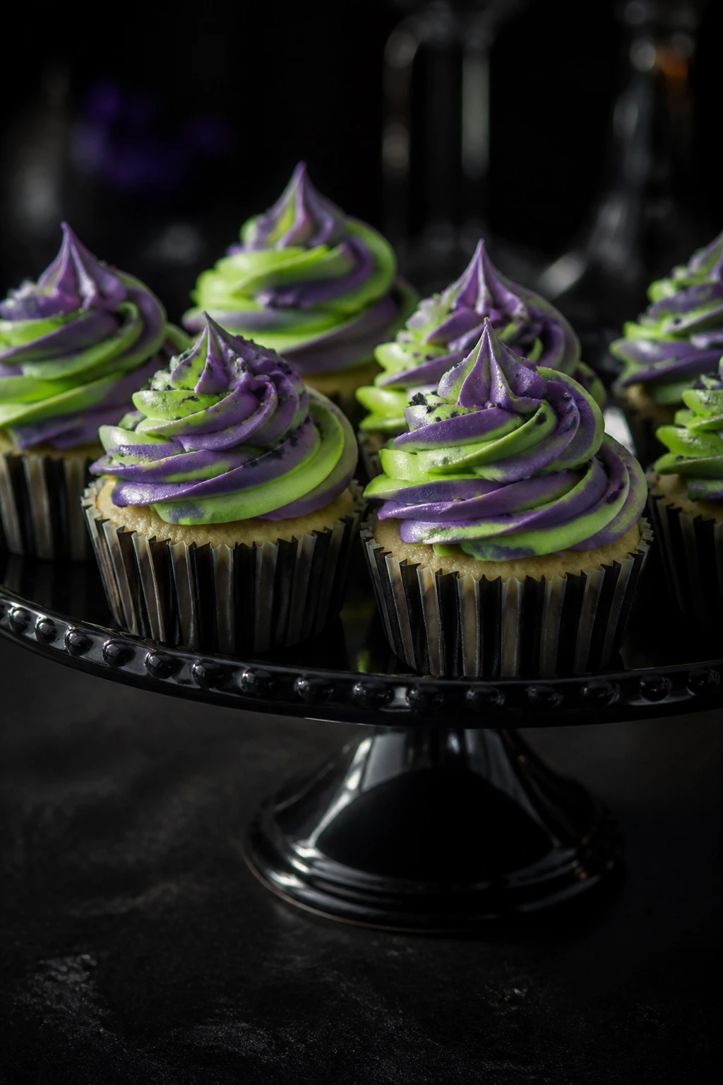 Beetlejuice cupcakes displayed on a black cake stand on a dark table