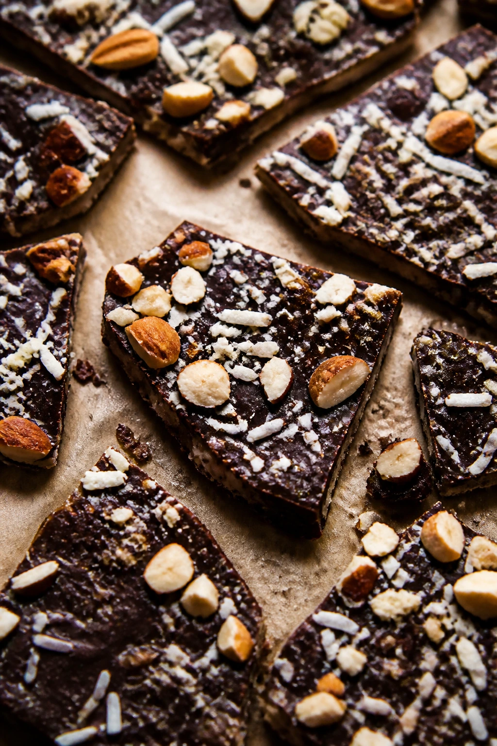 Chocolate coconut date bark on parchment with almonds