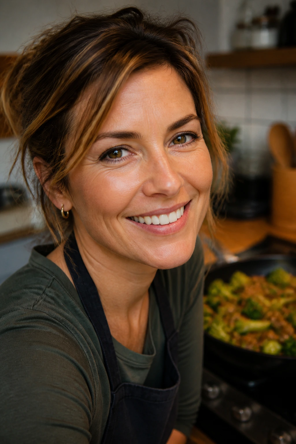 Smiling home cook in a warm kitchen with hamburger broccoli skillet in the background