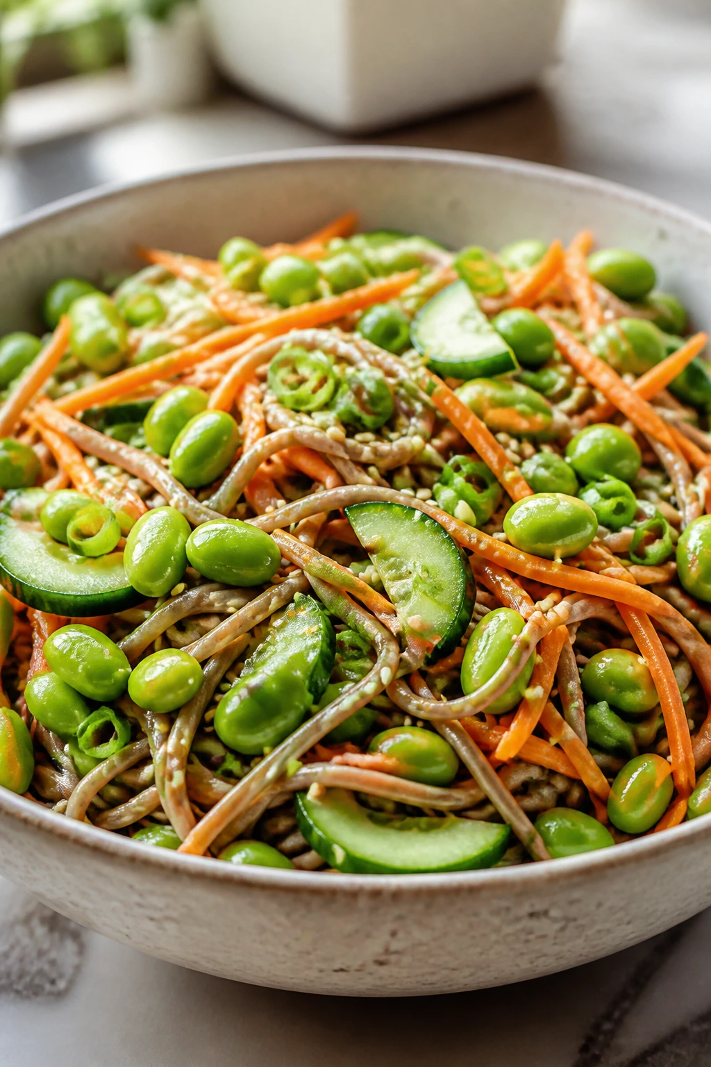 Bowl of edamame soba salad with cucumber and carrot.