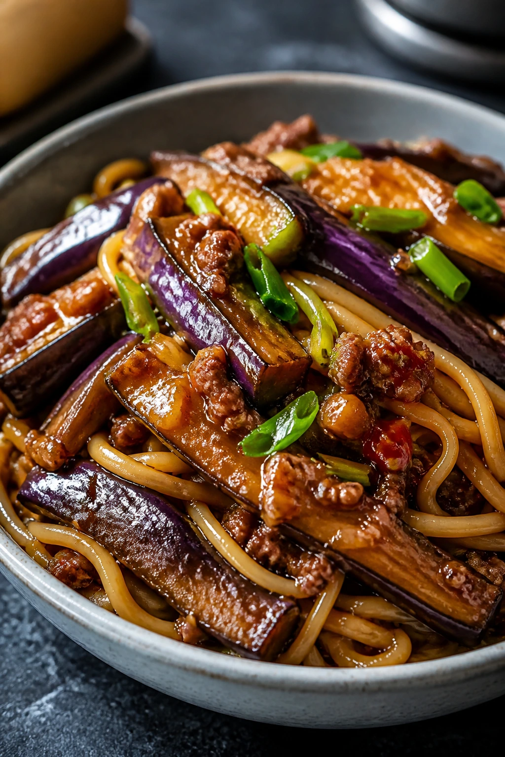Close-up of Fish-Fragrant Eggplant Noodles with glossy eggplant and noodles in yu xiang sauce.
