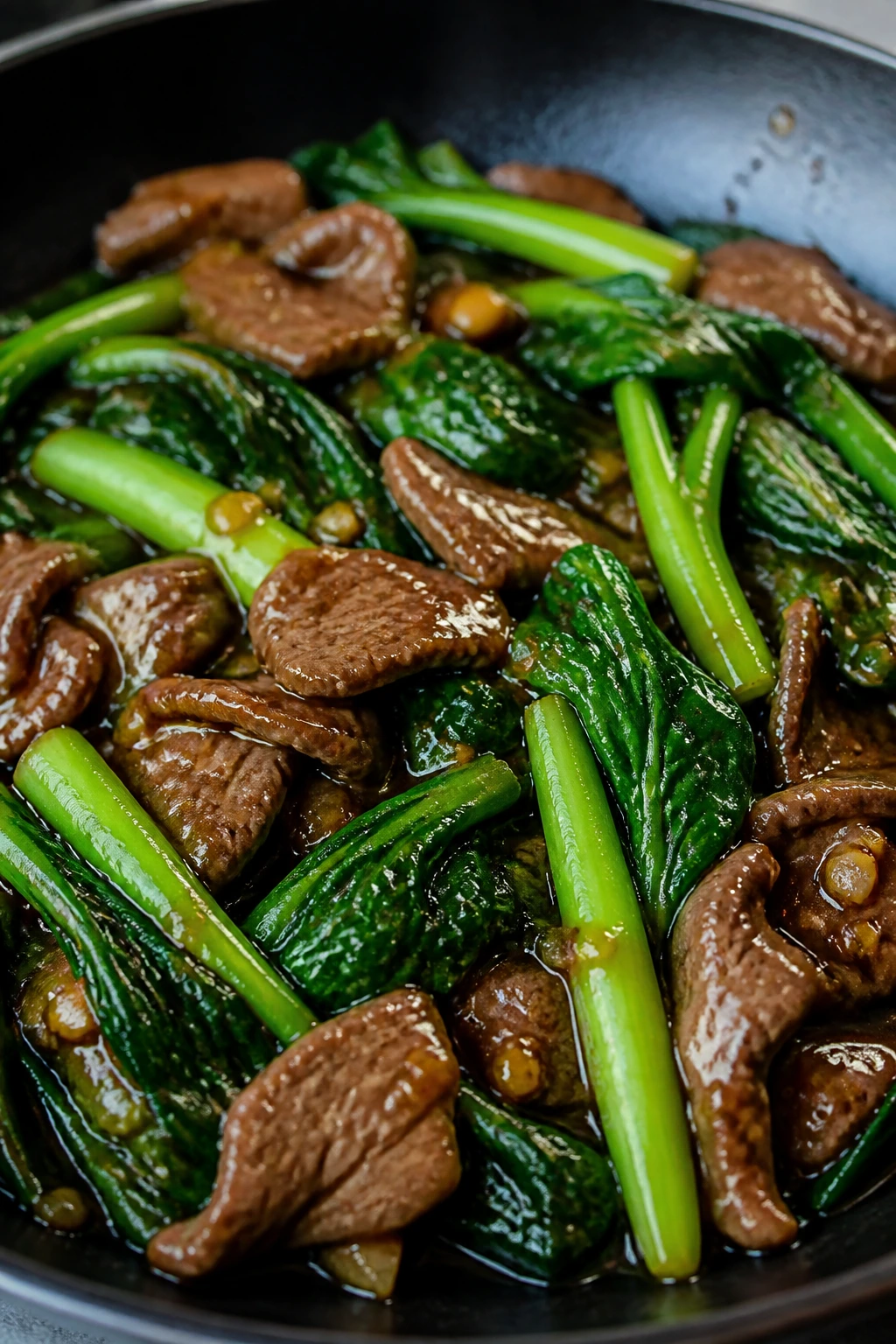 Gai lan with beef and oyster sauce in a skillet